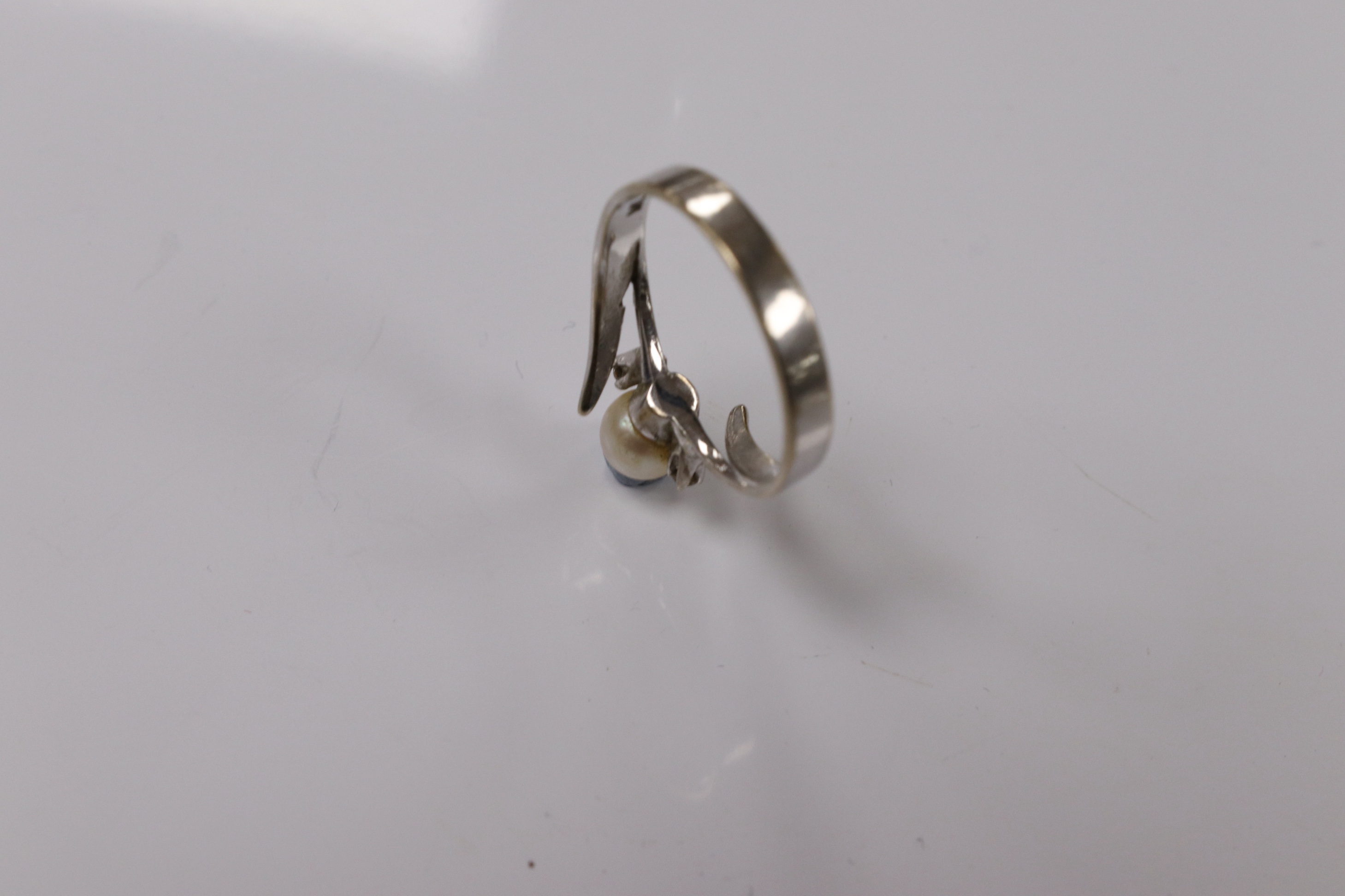 A modern 18ct white gold and single stone cultured pearl set ring, with two stone diamond set shoulders, size Q, gross weight 3.7 grams. Condition - poor to fair